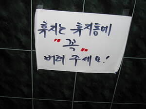 Sign taped accross from toilet